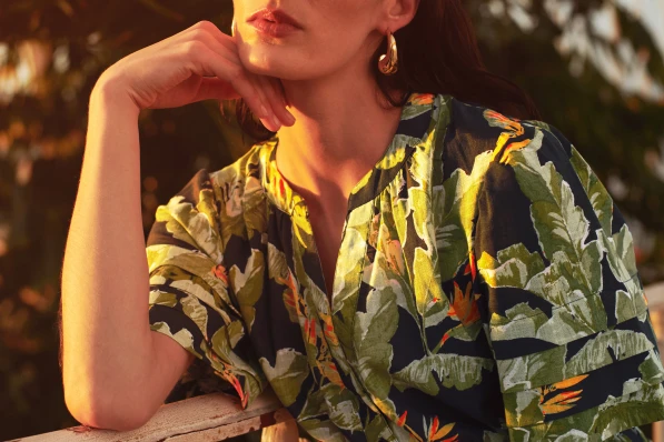 green and black dress with gold earrings